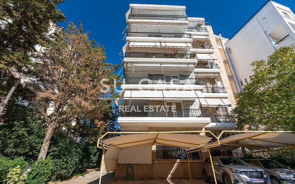 Άποψη πολυκατοικίας με μπαλκόνια και πράσινο περιβάλλον, ιδανική για κατοικία ή επένδυση.