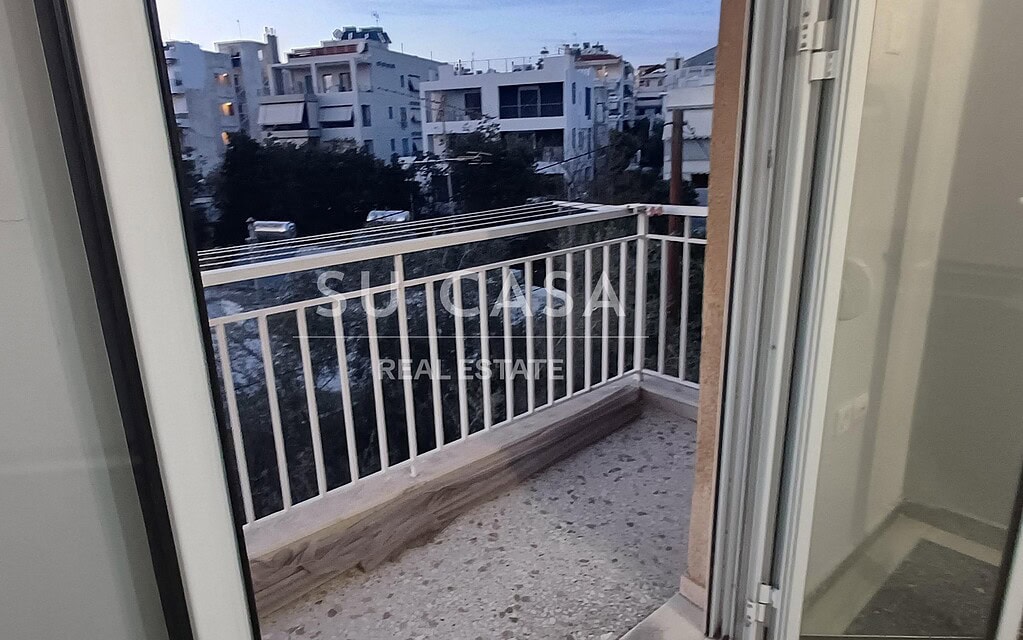 Άνετο μπαλκόνι με όμορφη θέα σε αστικά κτίρια, ιδανικό για χαλάρωση και απολαυστικές στιγμές.