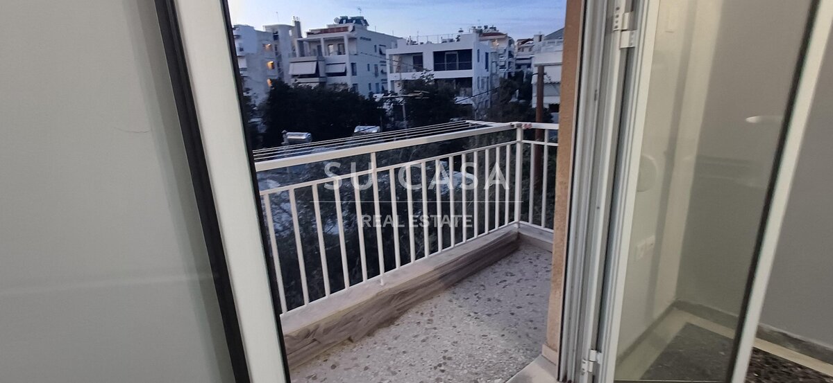 Άνετο μπαλκόνι με όμορφη θέα σε αστικά κτίρια, ιδανικό για χαλάρωση και απολαυστικές στιγμές.