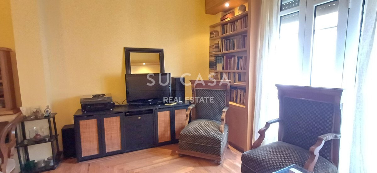 Άνετο σαλόνι με βιβλιοθήκη και τηλεόραση σε μοντέρνο σπίτι.