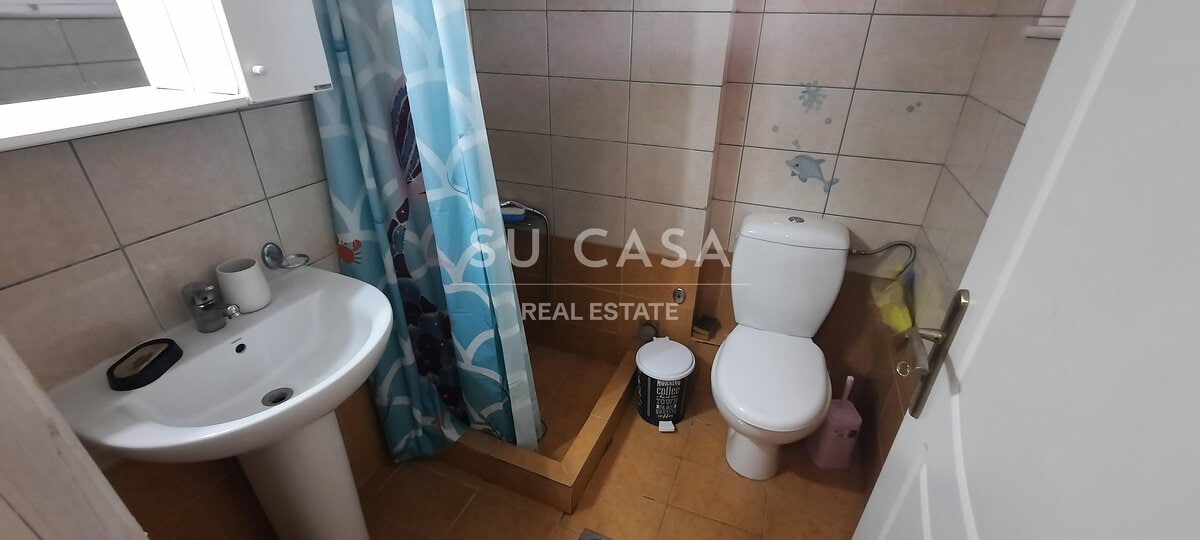 Άνετο μπάνιο με λευκό WC και νιπτήρα, ιδανικό για κατοικ.