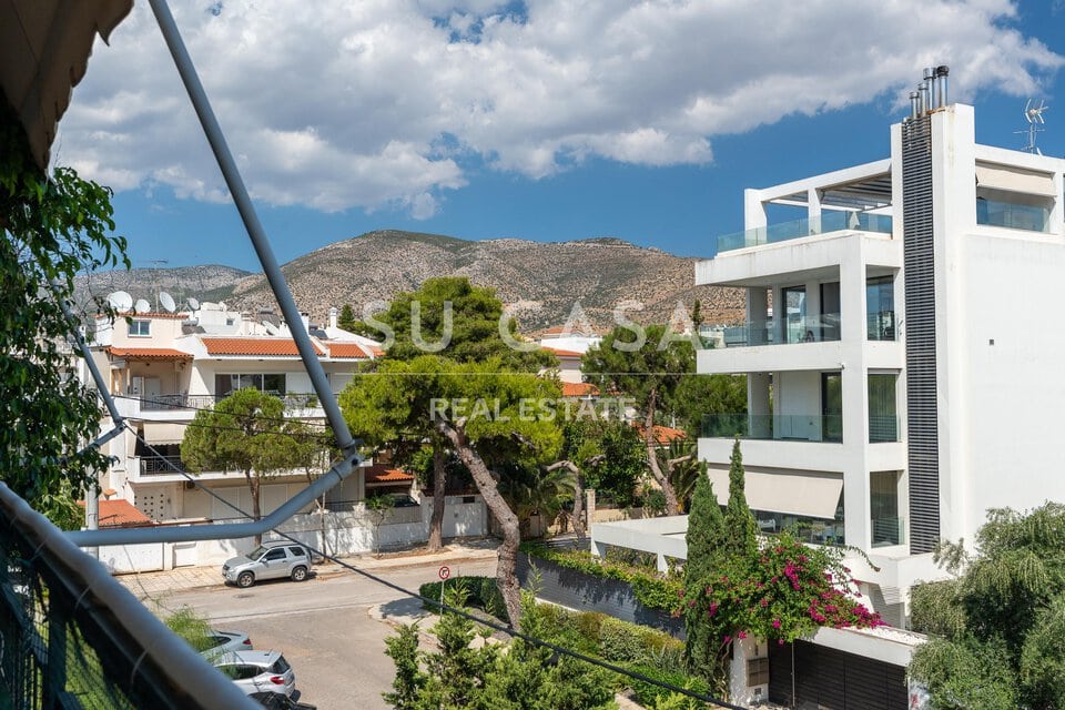 Μοντέρνο διαμέρισμα με μπαλκόνι και θέα σε βουνά και πράσινο.