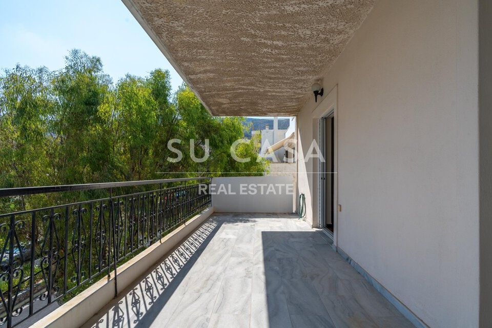 Μπαλκόνι με θέα σε πράσινο και ουρανό, ιδανικό για χαλάρωση.