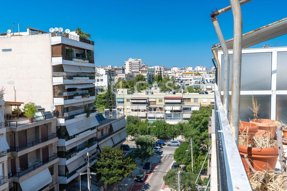 Θέα από μπαλκόνι σε πολυκατοικίες και δρόμο στην Αθήνα, καλοκαίρι, καθαρός ουρανός.