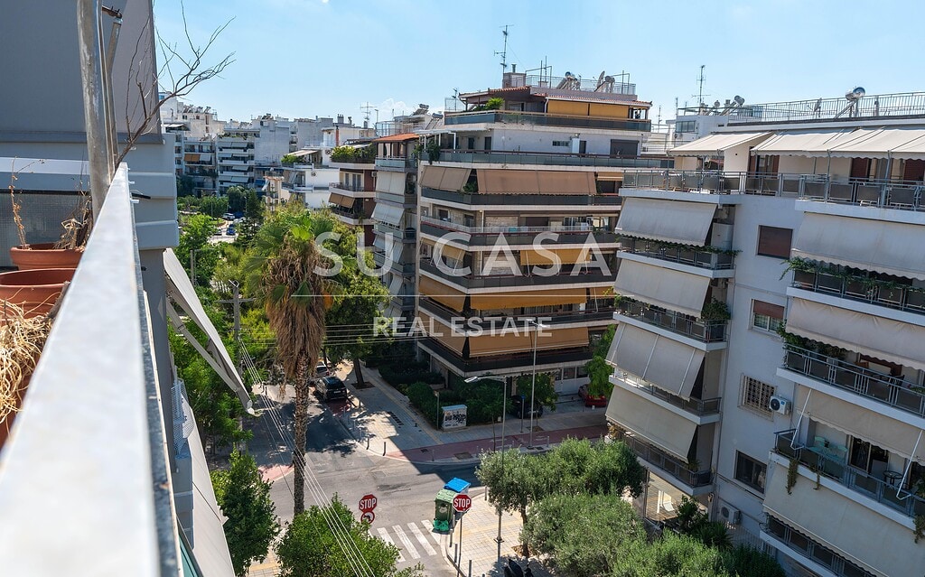 Πολυκατοικίες στην Αθήνα με πράσινο και δρόμους.