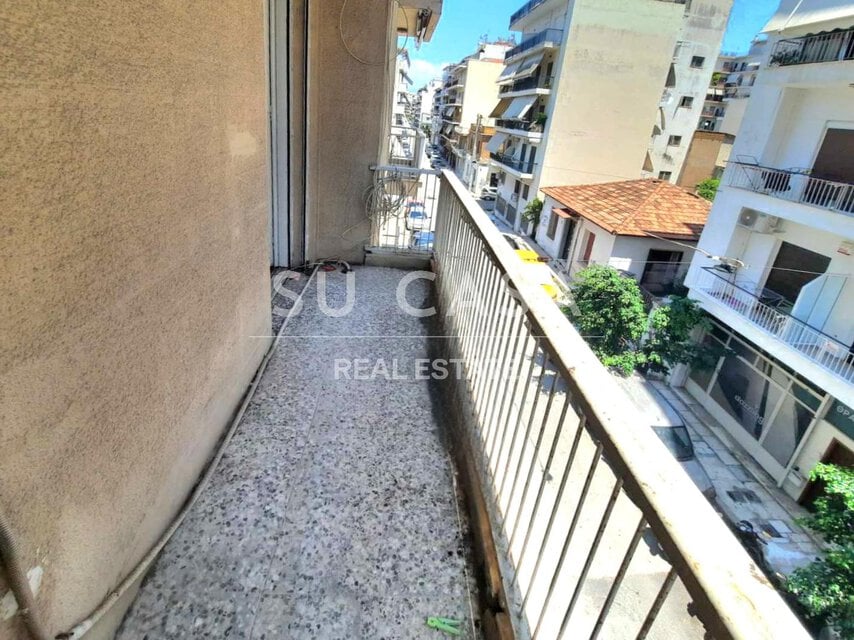 Μπαλκόνι με θέα σε πολυκατοικίες και δρόμο στην Αθήνα.