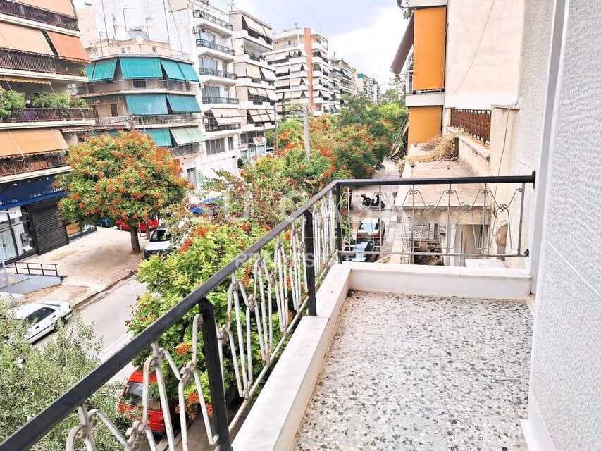 Μπαλκόνι με θέα σε πολυκατοικίες και δρόμο στα Κάτω Πατήσια.