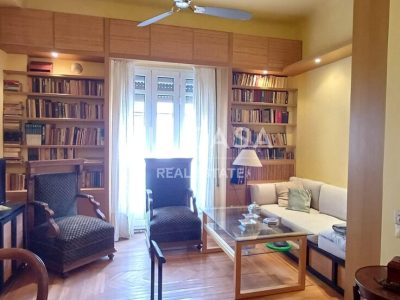 Άνετο σαλόνι με βιβλιοθήκη και φυσικό φως, ιδανικό για χαλάρωση και διασκέδαση.