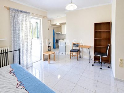 Εσωτερική άποψη γκαρσονιέρας με καθιστικό και κουζίνα στην Πάτρα.